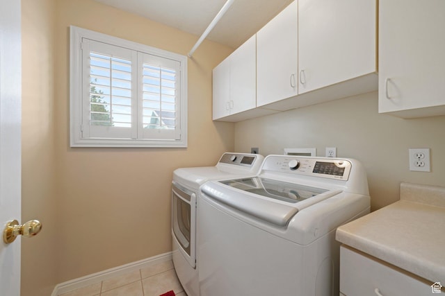 laundry room with cabinet space, separate washer and dryer, light tile patterned floors, and baseboards