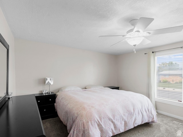 carpeted bedroom with baseboards, a textured ceiling, and ceiling fan