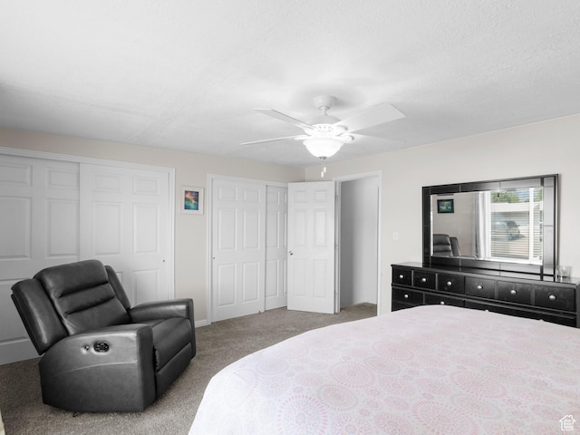 bedroom featuring multiple closets, carpet flooring, a ceiling fan, and baseboards