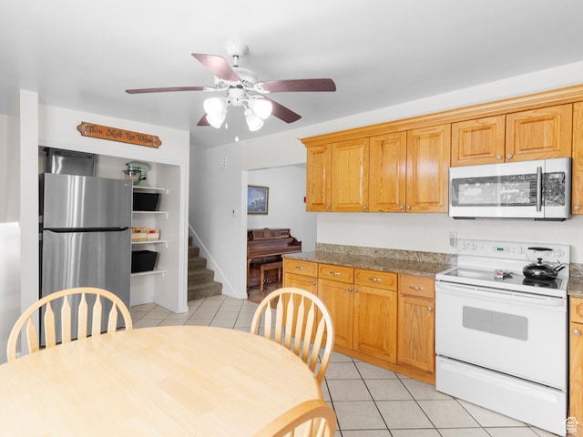kitchen with stainless steel appliances, light tile patterned floors, ceiling fan, and light countertops