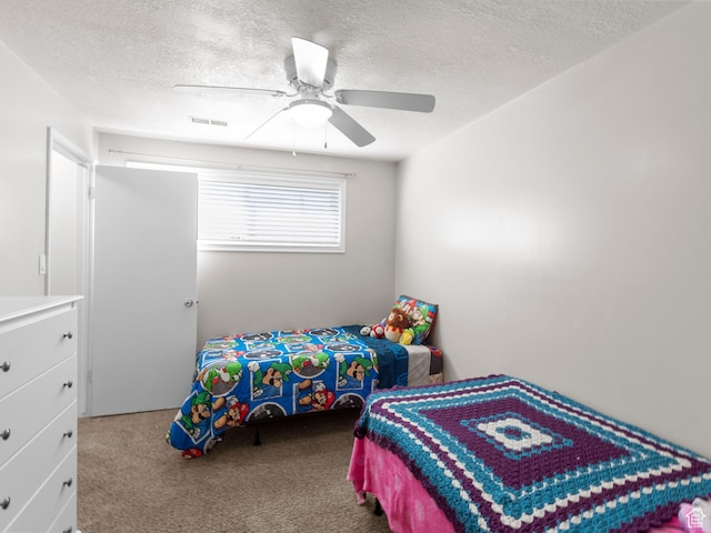 bedroom featuring carpet, a textured ceiling, and a ceiling fan