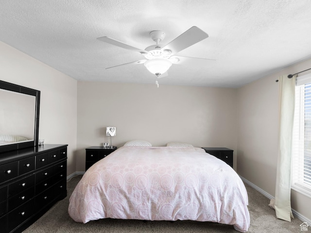 carpeted bedroom with baseboards, a textured ceiling, and ceiling fan