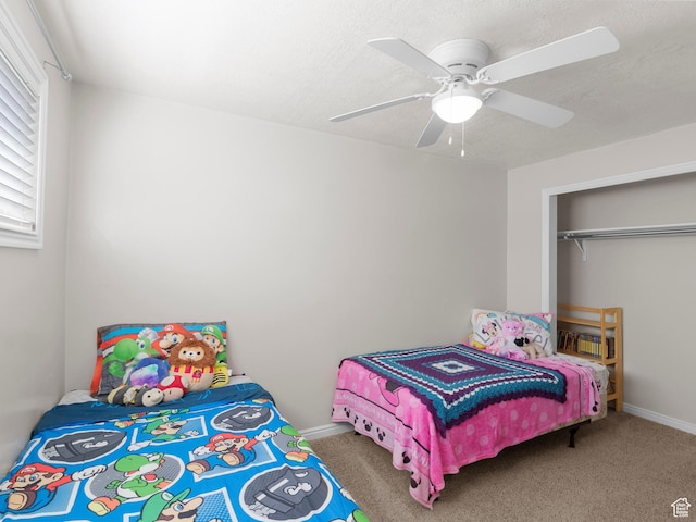 carpeted bedroom with a ceiling fan, baseboards, and a closet