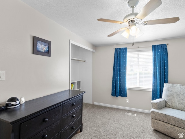 sitting room featuring carpet flooring, a ceiling fan, a textured ceiling, and baseboards