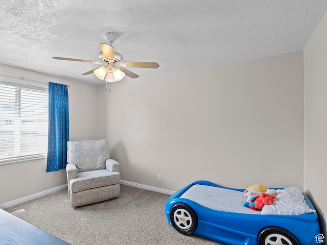 bedroom with baseboards, carpet floors, a textured ceiling, and ceiling fan