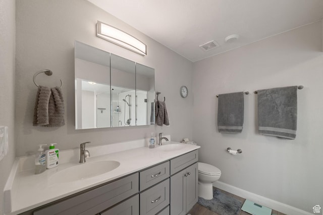 full bathroom featuring toilet, double vanity, and a stall shower