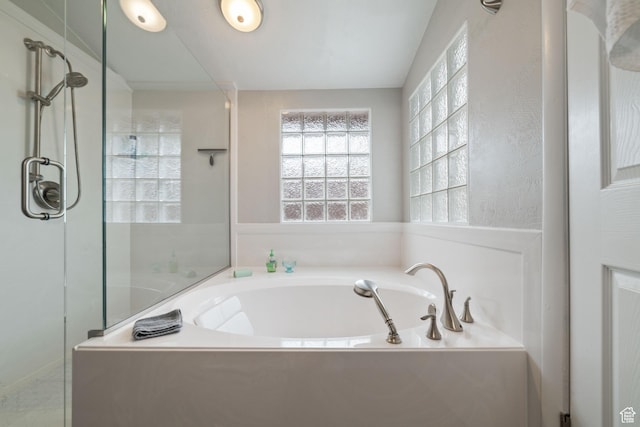 full bathroom with a shower stall and a bath