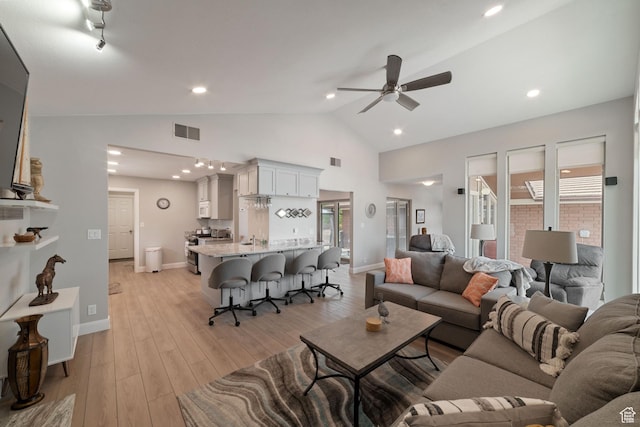 living room with ceiling fan, light wood finished floors, lofted ceiling, baseboards, and recessed lighting