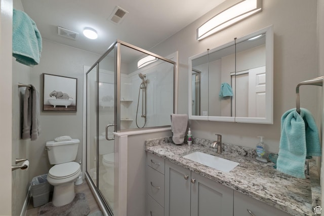 full bathroom featuring toilet, vanity, and a stall shower