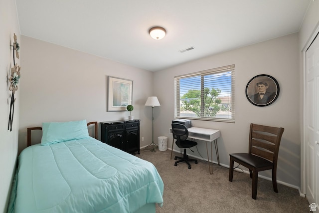 carpeted bedroom featuring baseboards and an office area