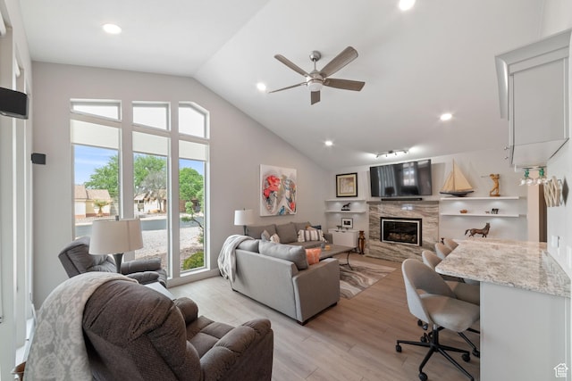 living room featuring a fireplace, a ceiling fan, light wood-type flooring, recessed lighting, and high vaulted ceiling