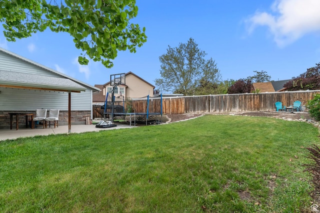 view of yard featuring a trampoline and a patio area