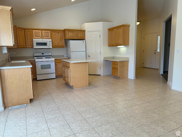kitchen with white appliances, a sink, a center island, light countertops, and high vaulted ceiling