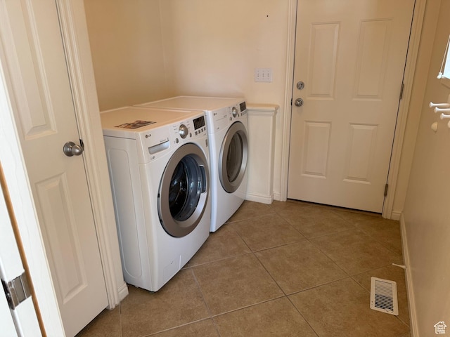 washroom featuring washing machine and dryer and light tile patterned flooring
