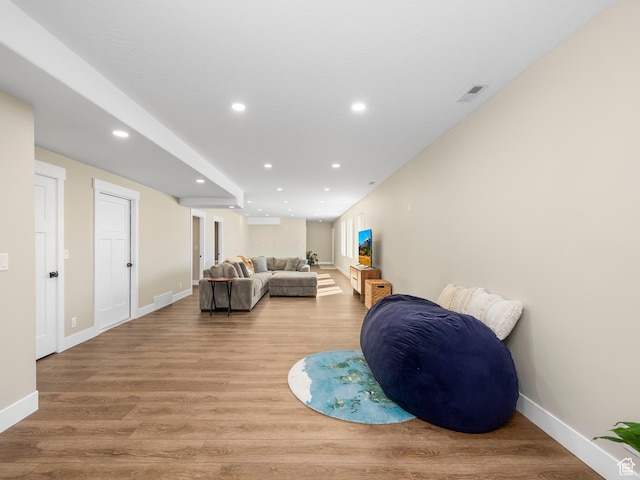 living area with wood finished floors, baseboards, and recessed lighting