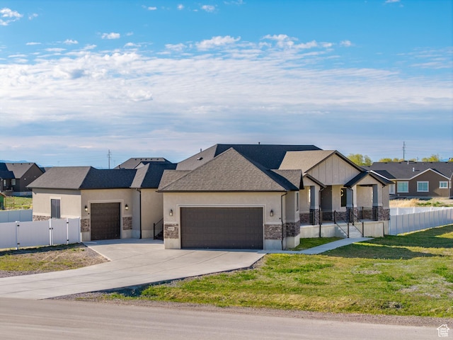 view of front facade with an attached garage, stone siding, concrete driveway, stucco siding, and a gate