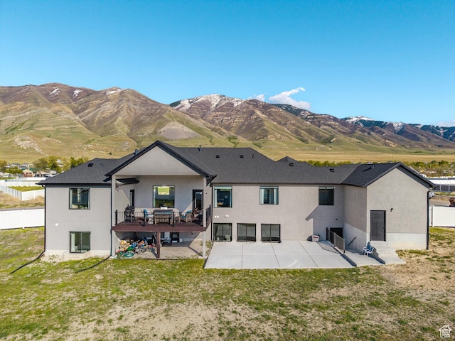 rear view of house with a patio area, stucco siding, and a mountain view