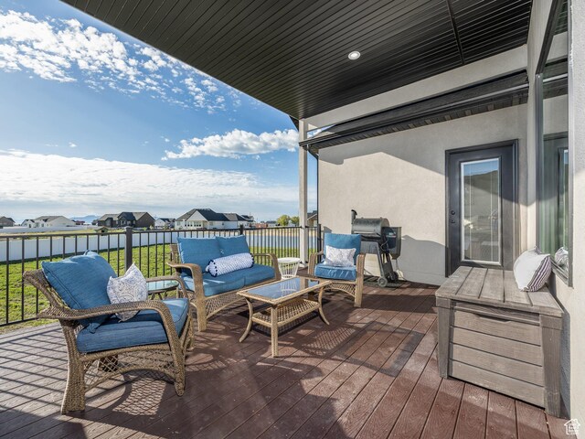wooden deck featuring outdoor lounge area, grilling area, and a residential view