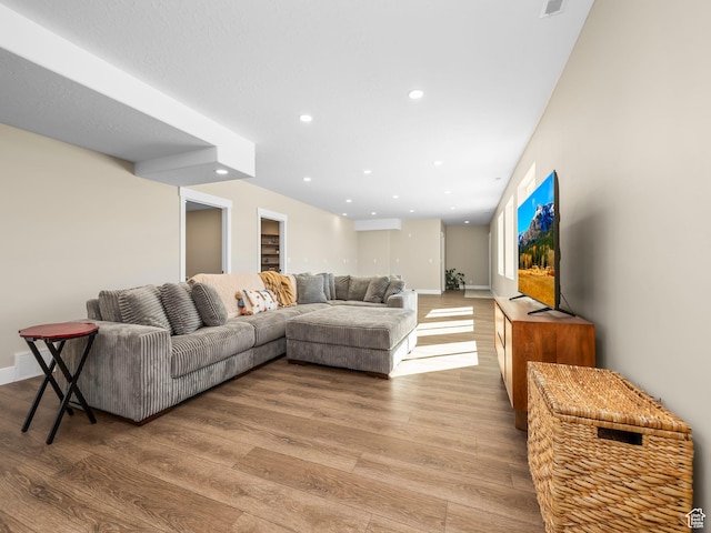 living area featuring light wood-type flooring, recessed lighting, and baseboards