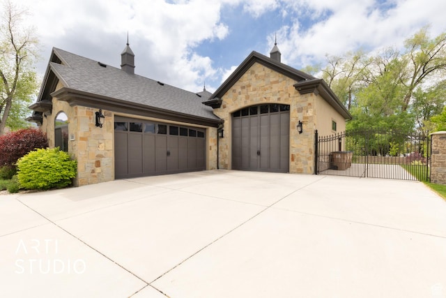 garage featuring fence, a gate, and concrete driveway