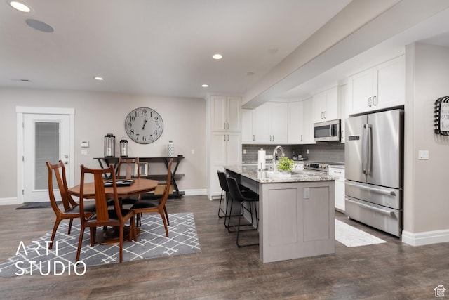 kitchen with stainless steel appliances, baseboards, tasteful backsplash, light stone countertops, and recessed lighting