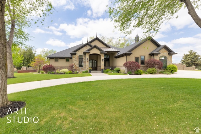 view of front of house featuring stone siding, a front yard, and stucco siding