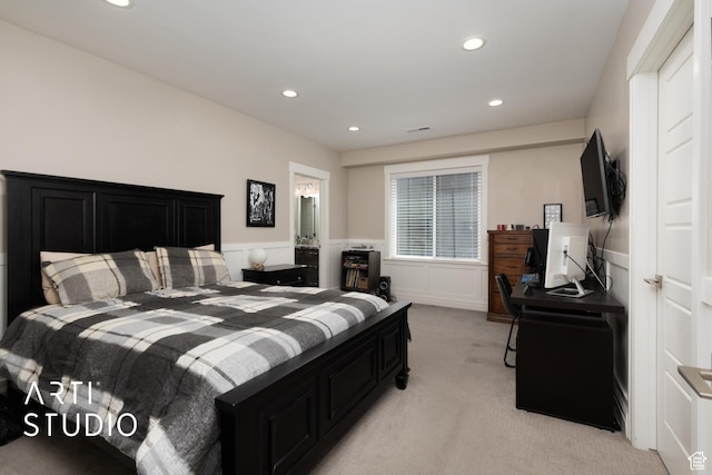 bedroom featuring light carpet, wainscoting, recessed lighting, and a desk