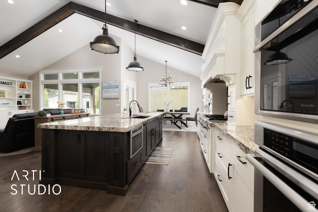 kitchen with stainless steel oven, a sink, white cabinets, beamed ceiling, and dark wood finished floors