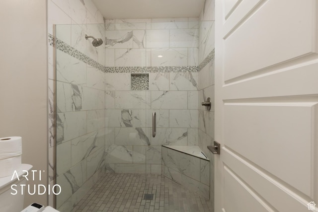 bathroom featuring a stall shower and toilet