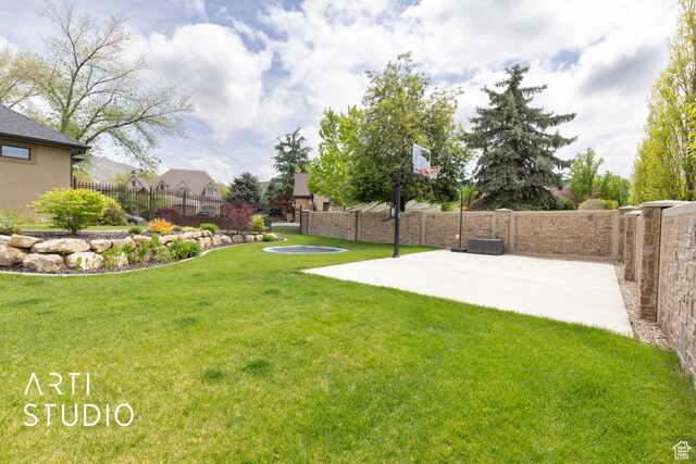 view of yard featuring basketball hoop and a residential view