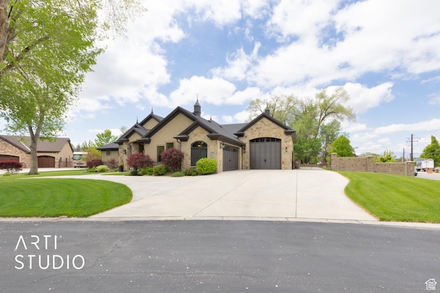 french country inspired facade featuring a garage, a front yard, stone siding, and driveway
