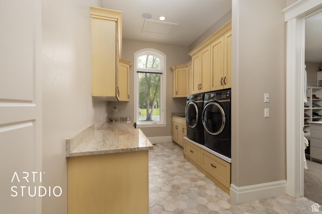 washroom with cabinet space, independent washer and dryer, baseboards, and attic access