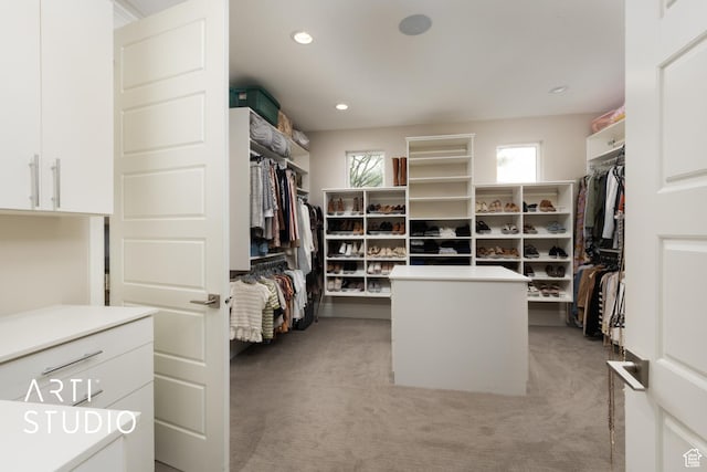 walk in closet featuring light colored carpet