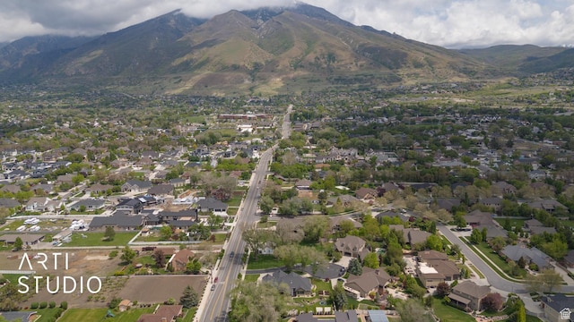 aerial view of property and surrounding area featuring a mountainous background and nearby suburban area