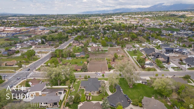 aerial view of property and surrounding area with nearby suburban area and a mountainous background