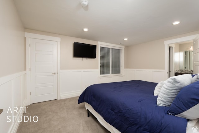 carpeted bedroom with wainscoting, a decorative wall, and recessed lighting