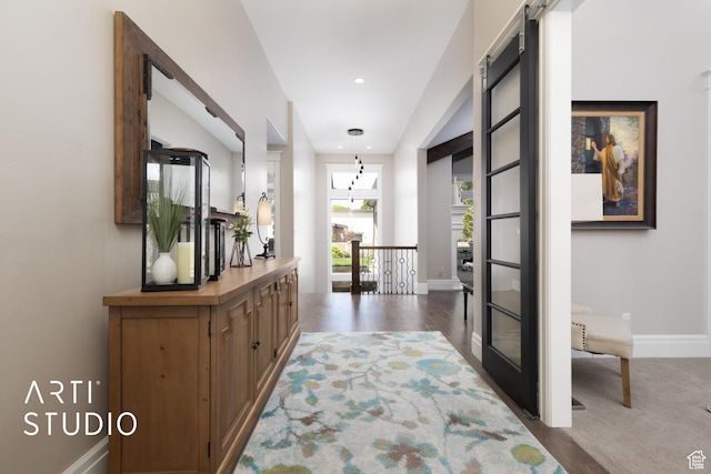 hall featuring baseboards, wood finished floors, an upstairs landing, and recessed lighting