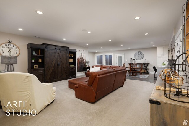 living area featuring a barn door, recessed lighting, and baseboards