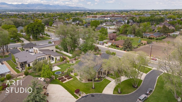 aerial view of property and surrounding area with nearby suburban area and a mountain backdrop