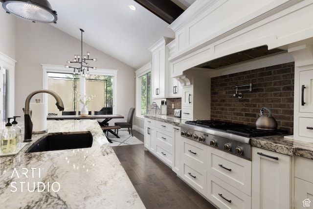kitchen featuring stainless steel gas cooktop, a sink, decorative backsplash, vaulted ceiling, and dark wood-style floors