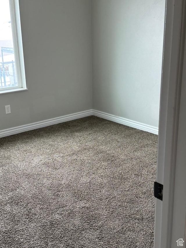 carpeted spare room with baseboards