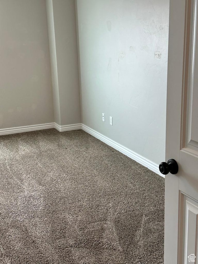 carpeted empty room with baseboards