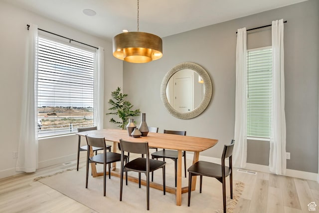 dining room with light wood-style flooring and baseboards