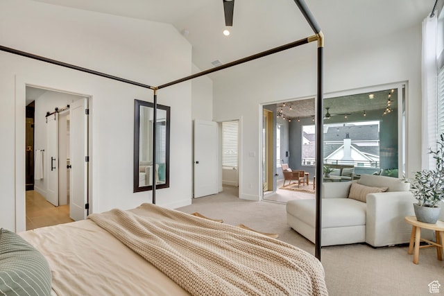 bedroom featuring a barn door, light carpet, baseboards, high vaulted ceiling, and access to outside