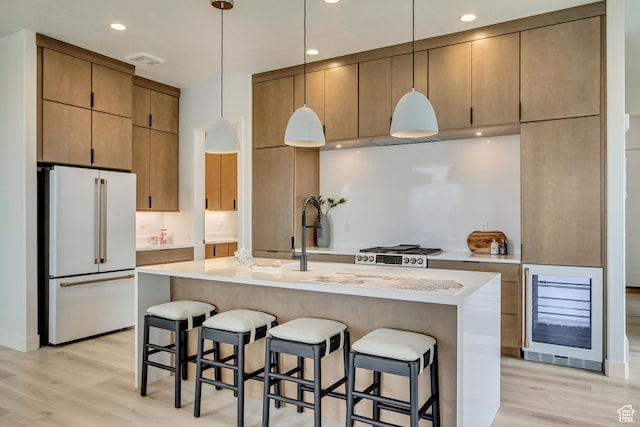 kitchen with freestanding refrigerator, beverage cooler, light wood finished floors, light countertops, and recessed lighting