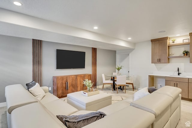 living area featuring recessed lighting, baseboards, and wet bar