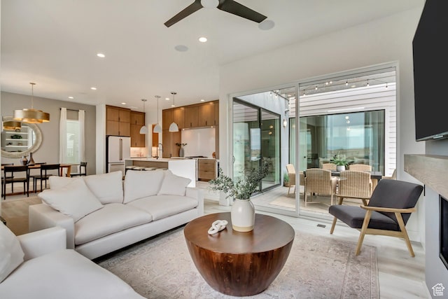 living room with ceiling fan, light wood-style floors, and recessed lighting