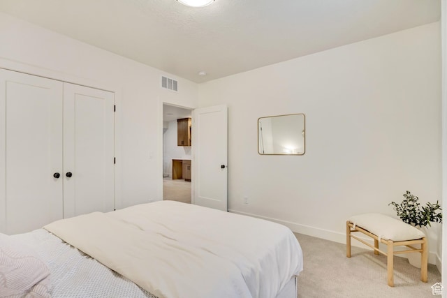 bedroom featuring light carpet, baseboards, and a closet