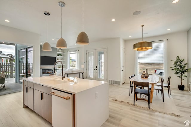 kitchen with a sink, light wood-style floors, recessed lighting, an island with sink, and healthy amount of natural light