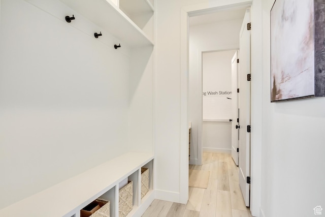 mudroom featuring light wood-style flooring and baseboards